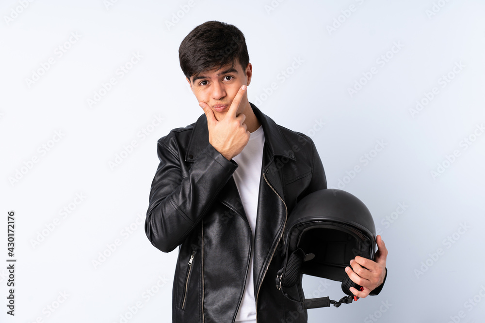 Man with a motorcycle helmet over isolated blue background thinking an idea
