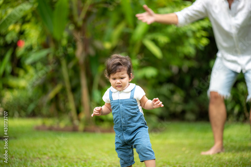 family person concept, father and baby child joy playing in the outdoor nature grass flower garden, having fun and happy smiling, childhood and parent love together in summer at home