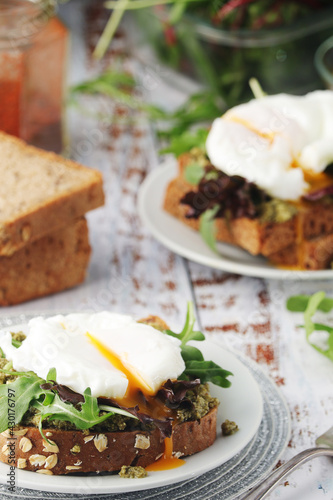 Homemade sandwiches with pesto, green salad and poached eggs