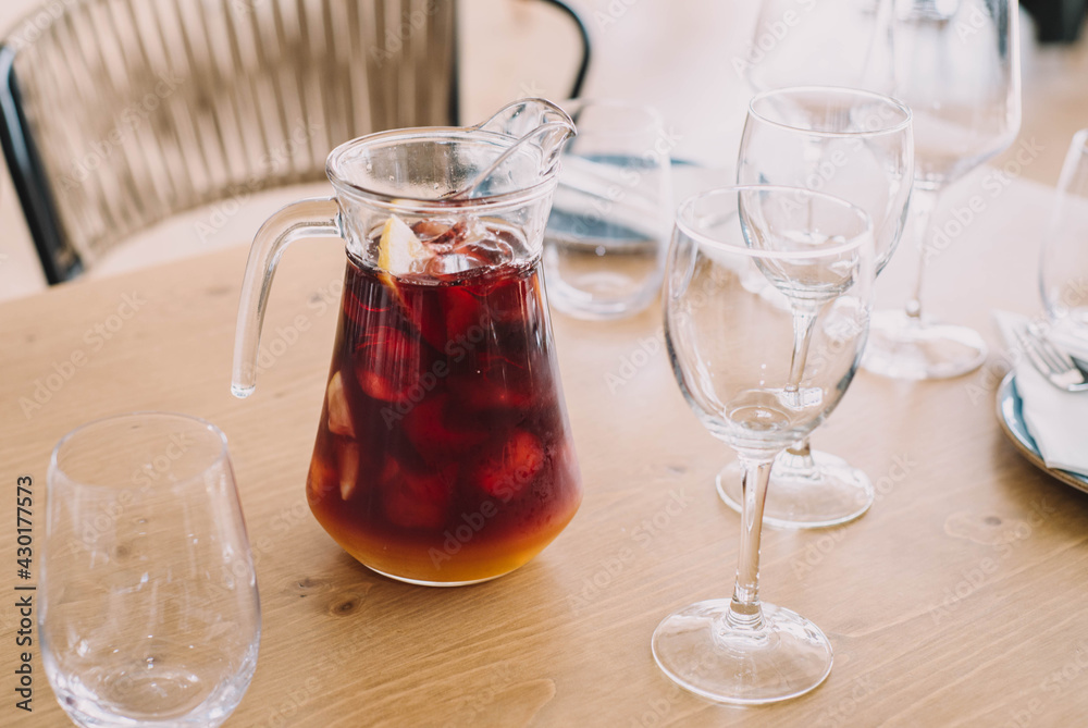 Jarra de litro de sangría hecha con vino tinto y zumos frutales, con dos copas en un restaurante Jarra de litro de sangría hecha con vino tinto y zumos frutales, con dos copas en un restaurante
