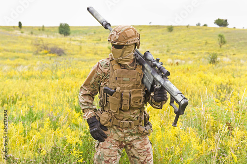 Fotografie Soldier in a special military uniform, with a helmet on his head and with a snip