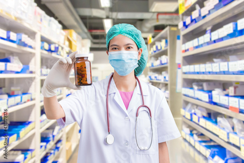 Doctor woman holding pill or medication in capsule. concept of pharmacist, drugs, diet pill, antibiotic or vitamin photo