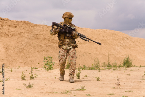 Equipped and armed special forces soldier with rifle in the desert.