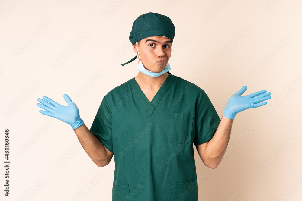 Surgeon man in blue uniform over isolated background having doubts with confuse face expression
