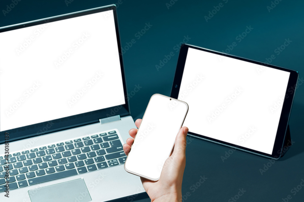 Set with smartphone, digital tablet and laptop with white screens for your design on blue background. Set with smartphone, digital tablet and laptop with white screens for your design on blue background.