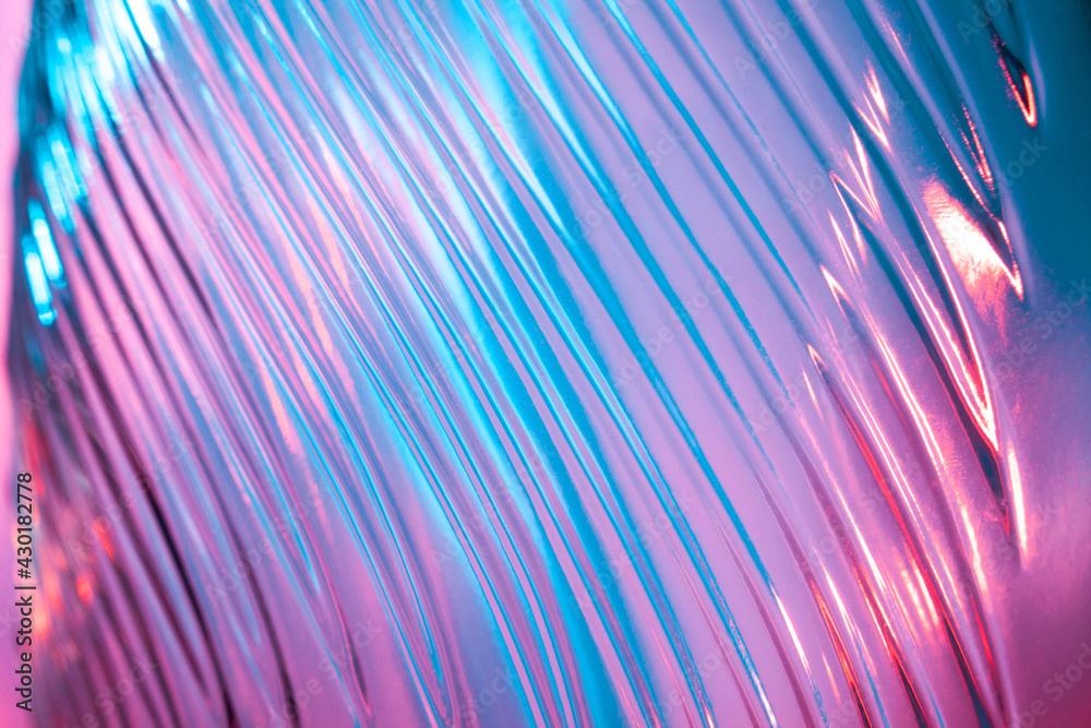 Abstract glass background. Texture of wavy glass illuminated with multi-colored light. Pink and blue stains. glass flares. Close up. - obrazy, fototapety, plakaty 