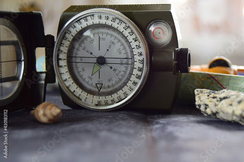 Travel reliability and confidence. Magnetic compass on a dark concrete background with stones and shells