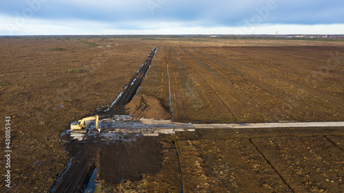 Aerial view to the new drainage network establishment for peat extraction field, next to the natural peat bog wetland. It is big environmental concern, and  source of greenhouse gases and biodiversity