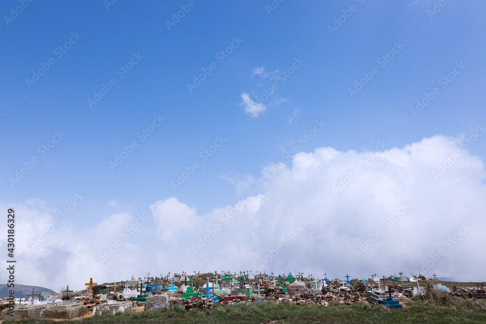 Fototapeta premium A view of Crosses above graves at a cemetery in a village.