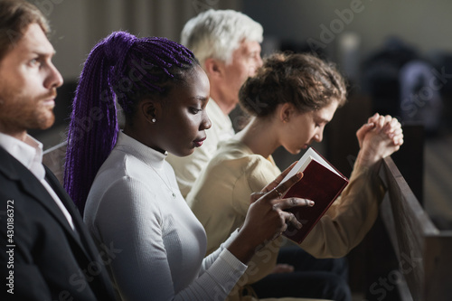 Canvas Print Group of people sitting on the bench in church and praying during ceremony