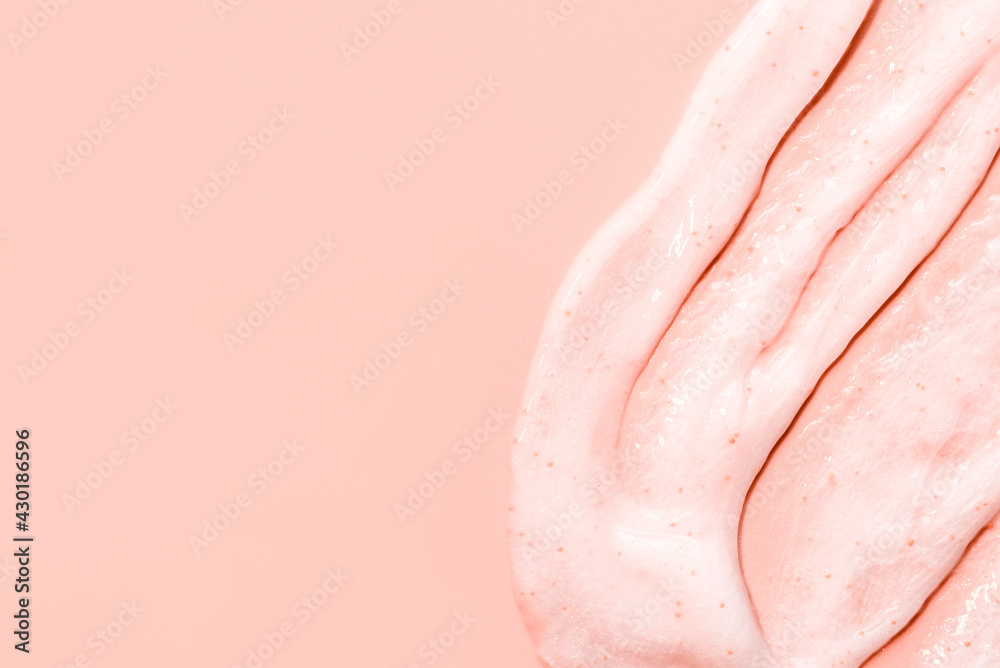 The texture of a scrub or shower gel on a pink background.