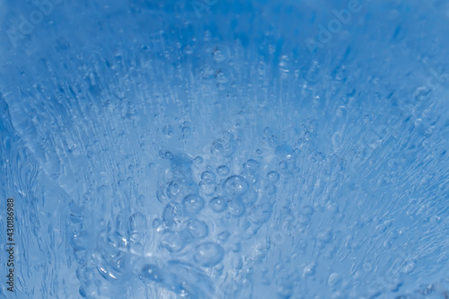 Air bubbles rise in the measures in the water on a blue background. Selective focus. Blur. The concept of Water Day, Clean Air Day. A comprehensive blue textured background