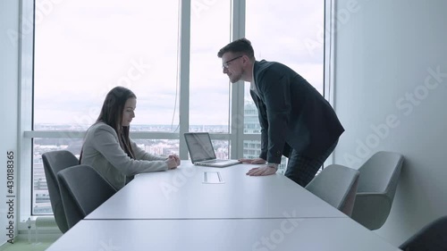 Young female employee receiving reprimand from male boss in business office slow motion