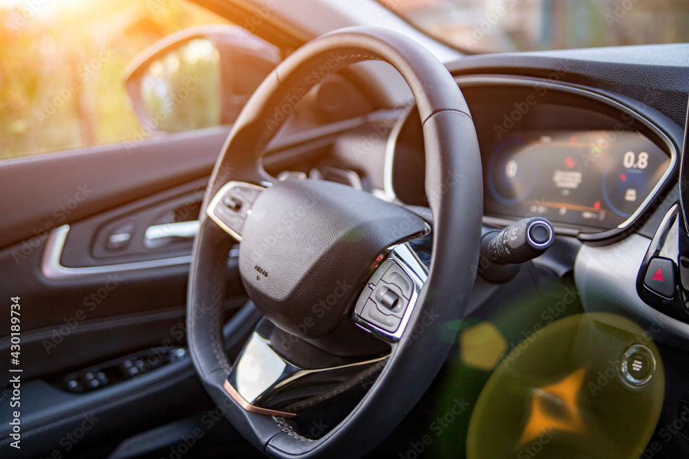 empty interior of modern premium car dark interior close-up steering wheel and drivers seat