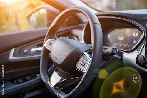empty interior of modern premium car dark interior close-up steering wheel and drivers seat