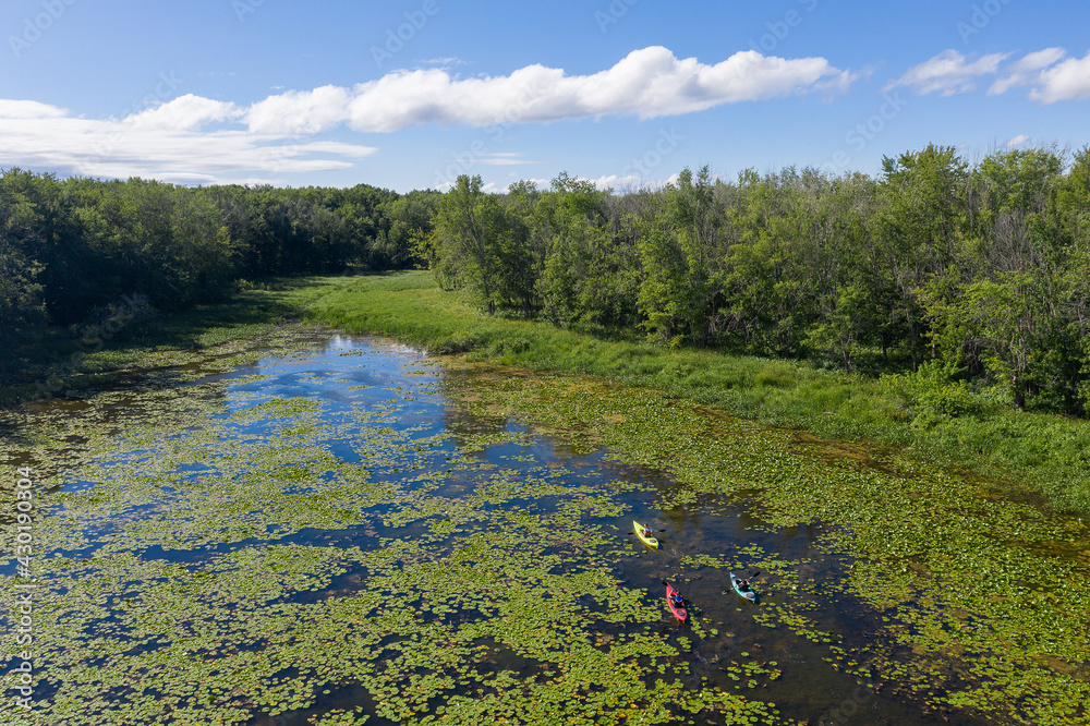Aerial drone photo of Grandfather, father and son kayaking in lily pads in the summer in Canadian wilderness