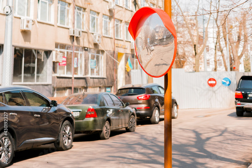 Reflection of the road from circular traffic convex mirror pole for car traffic safety. Viewing mirror. Parking. Road. Street. City. Urban. Safety