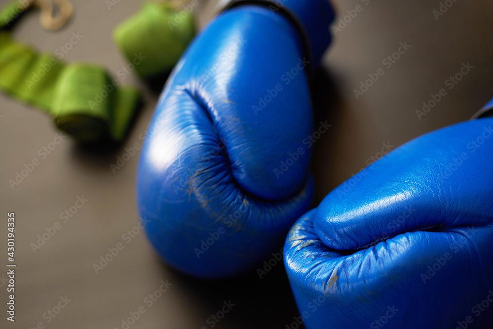 Blue boxing gloves, sports bandages out of focus, close-up.
