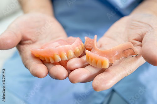 Asian senior or elderly old woman patient holding to use denture in nursing hospital ward, healthy strong medical concept