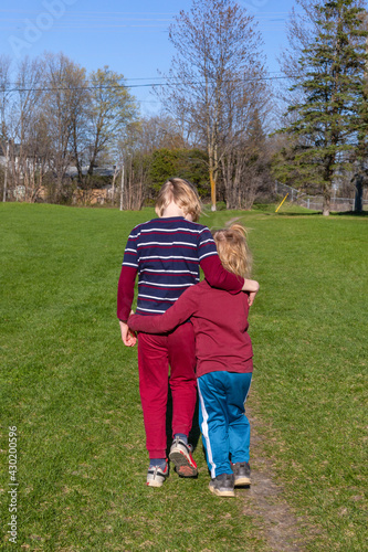 Children walking in the park in spring. Siblings hugging © Iryna