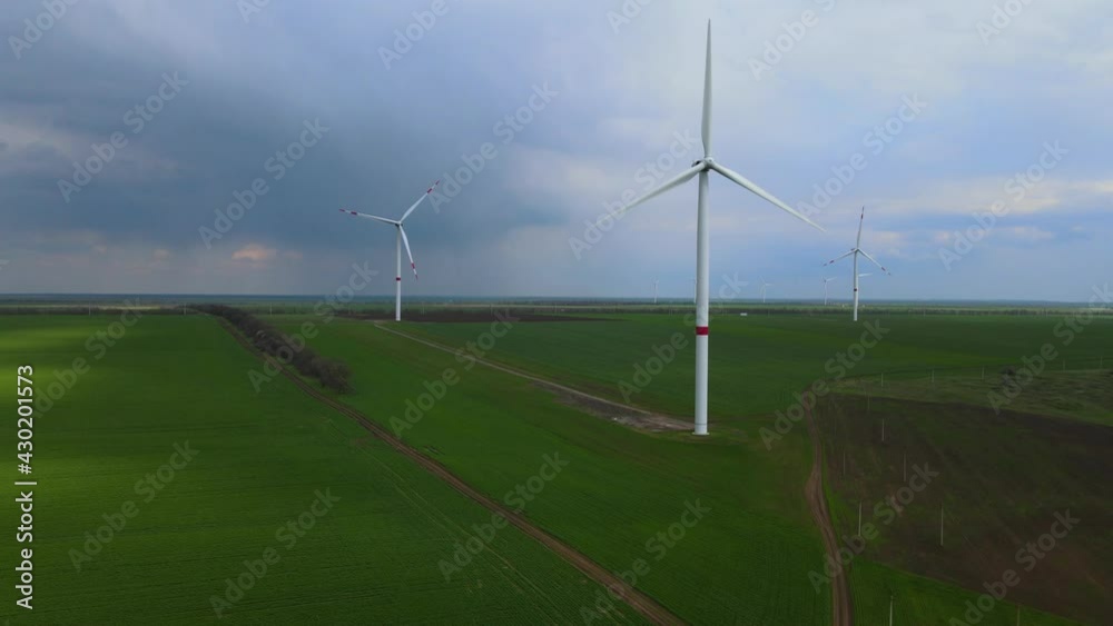 Wind farms that generate clean renewable energy for sustainable development. Alternative energy. Large wind turbines with blades in the field aerial view. Wind farms that generate clean renewable energy for sustainable development. Alternative energy. Large wind turbines with blades in the field aerial view.