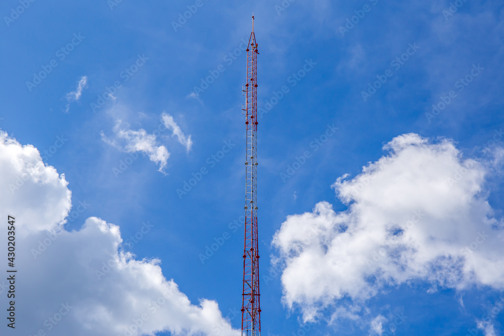 Telecommunication tower with white clouds and the blue sky. Telecommunication tower with white clouds and the blue sky.