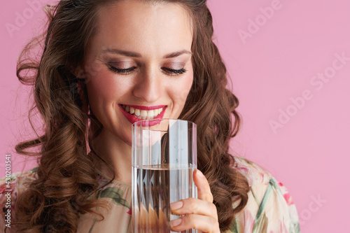 smiling trendy woman with long wavy brunette hair on pink