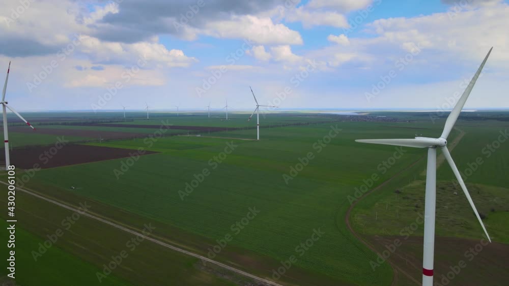 Wind farms that generate clean renewable energy for sustainable development. Alternative energy. Large wind turbines with blades in the field aerial view.