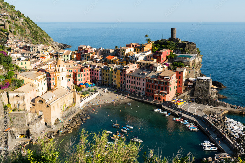 Vernazza,Liguria,Italy. June 2020. A viewpoint from the top of the hill towards the seaside village. The colorful houses stand out. People bathe in the waters of the marina. Famous tourist destination