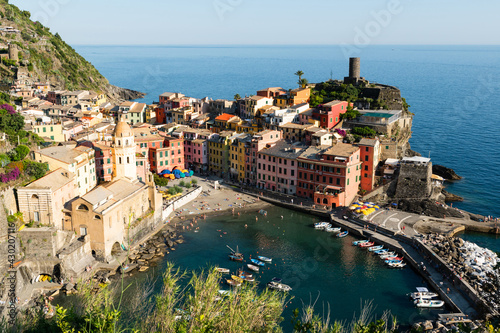 Vernazza Liguria Italy. June 2020. A viewpoint from the top of the hill towards the seaside village. The colorful houses stand out. People bathe in the waters of the marina. Famous tourist destination