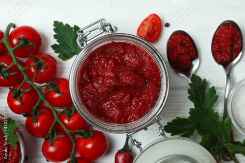 Fotografie, Obraz Jar with tomato paste on white wooden background with ingredients