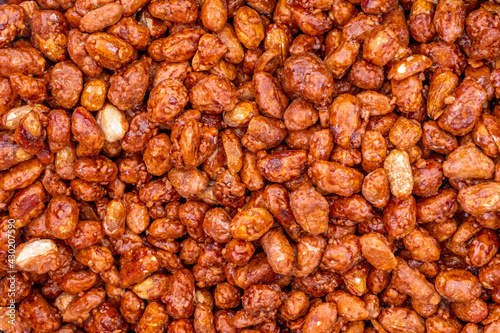 Sugar peanuts background and texture on the street market. Glazed and roasted peanuts