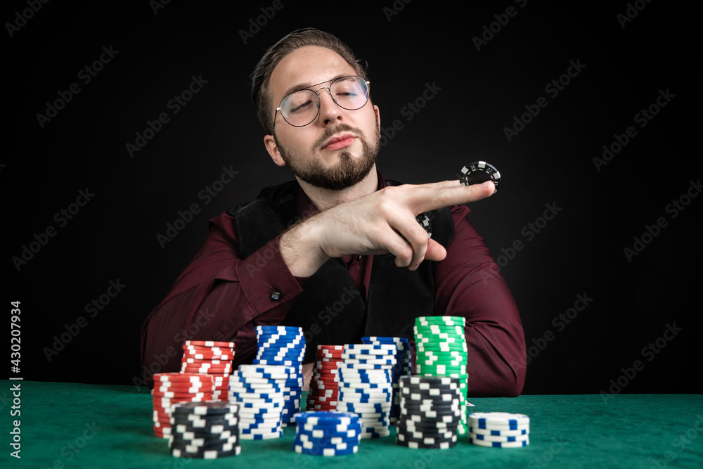 A young poker player has a lot of chips on the table. A young poker player has a lot of chips on the table.