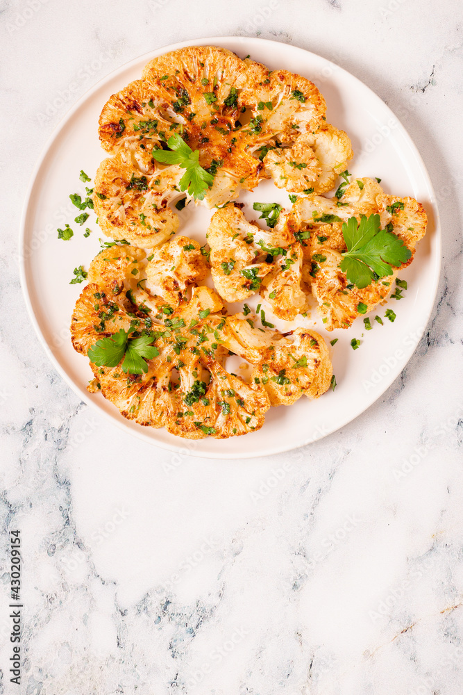 Cauliflower steak with spices cooked in the oven, top view. Cauliflower steak with spices cooked in the oven, top view.