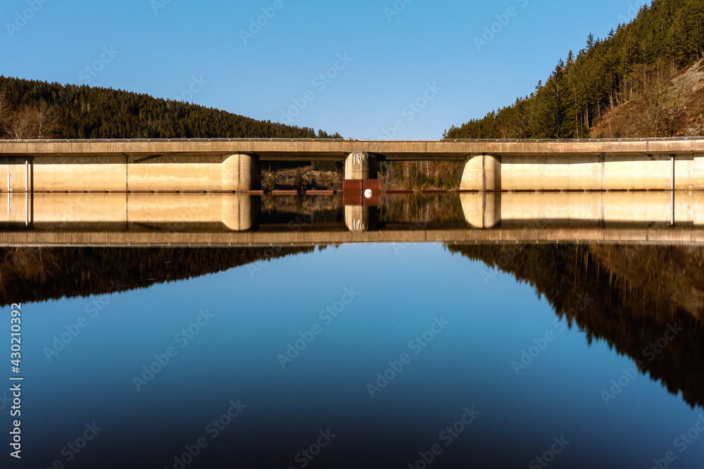 Okertalsperre, Oker Dam in the forest of the Harz mountains in Lower Saxony, Germany. Harz Germany landscape with beautiful blue and calm water of the Oker reservoir.