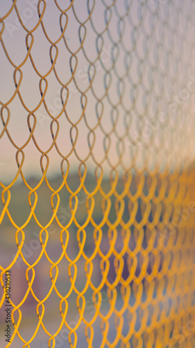 Close up of yellow metal grid on the soft colors of sky. The beginning of the season for outdoor sports