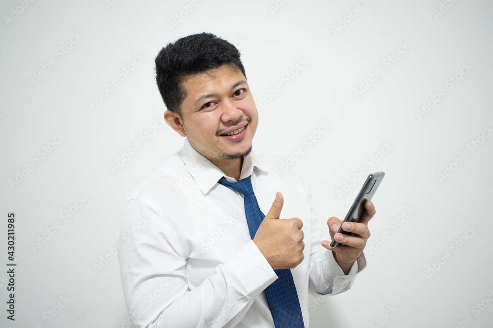 Young Asian businessman with mobile phone on light background Young Asian businessman with mobile phone on light background