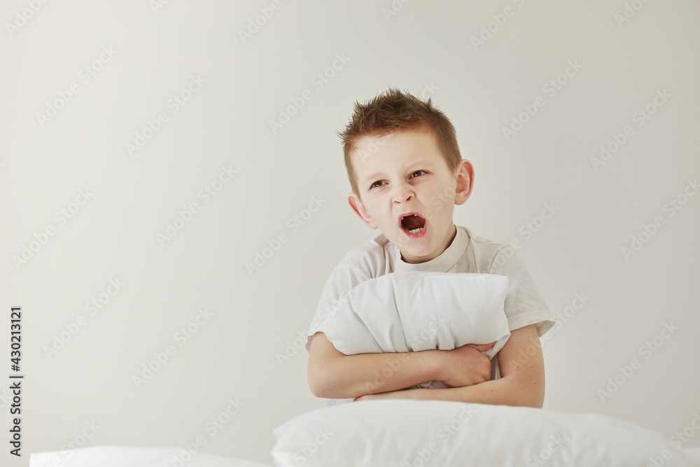 child boy wakes up and stretching on his comfortable bed in morning, Health care and good morning world concept. Stretches and yawns. child boy wakes up and stretching on his comfortable bed in morning, Health care and good morning world concept. Stretches and yawns.
