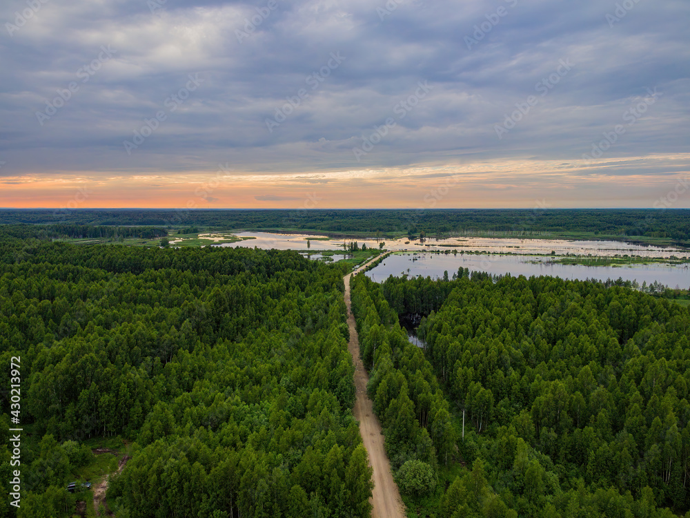 Bird's eye view of the sunset over the lake in the forest