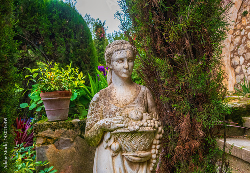 Beautiful stone sculpture in the shape of a woman  used as a decoration in a park.