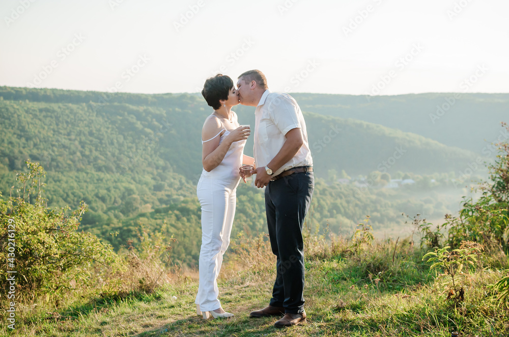 Newlyweds hug and kiss on the background of the forest. A man hugs and kisses a woman