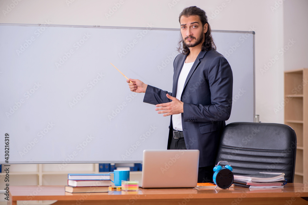 Young male teacher in the classroom Young male teacher in the classroom