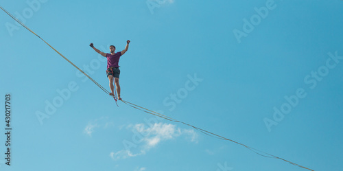 Highliner on the background of blue sky.