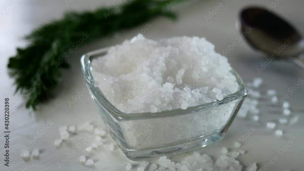 Chef with fingers take a pinch of coarse sea salt from the salt shaker on the kitchen table for preparation savory tasty food. Close-up. Chef with fingers take a pinch of coarse sea salt from the salt shaker on the kitchen table for preparation savory tasty food. Close-up.