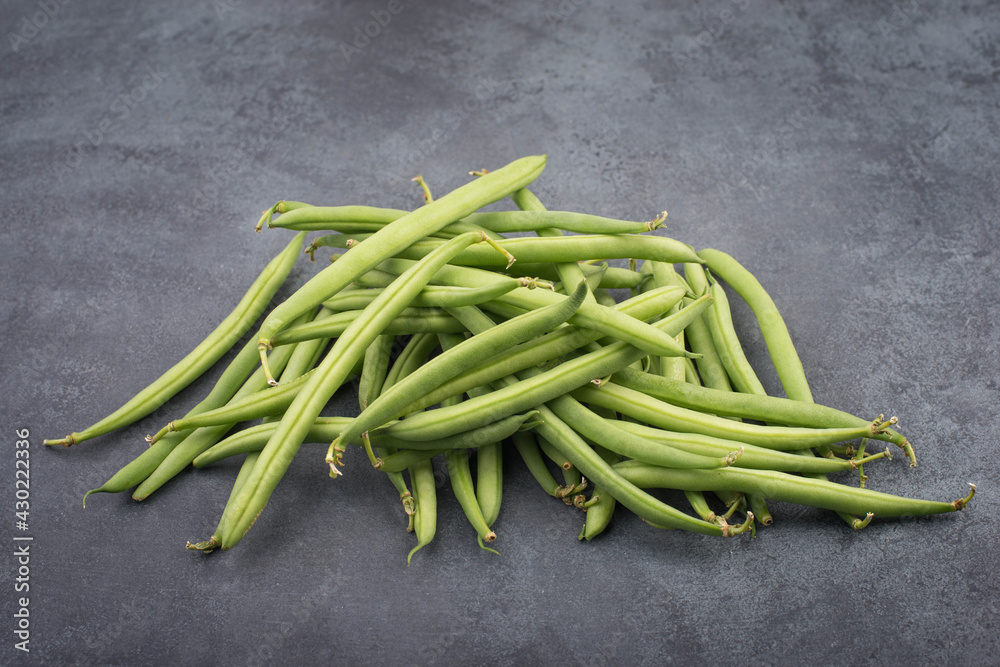 Green string beans on a textured background, empty space for text, vegetables Green string beans on a textured background, empty space for text, vegetables
