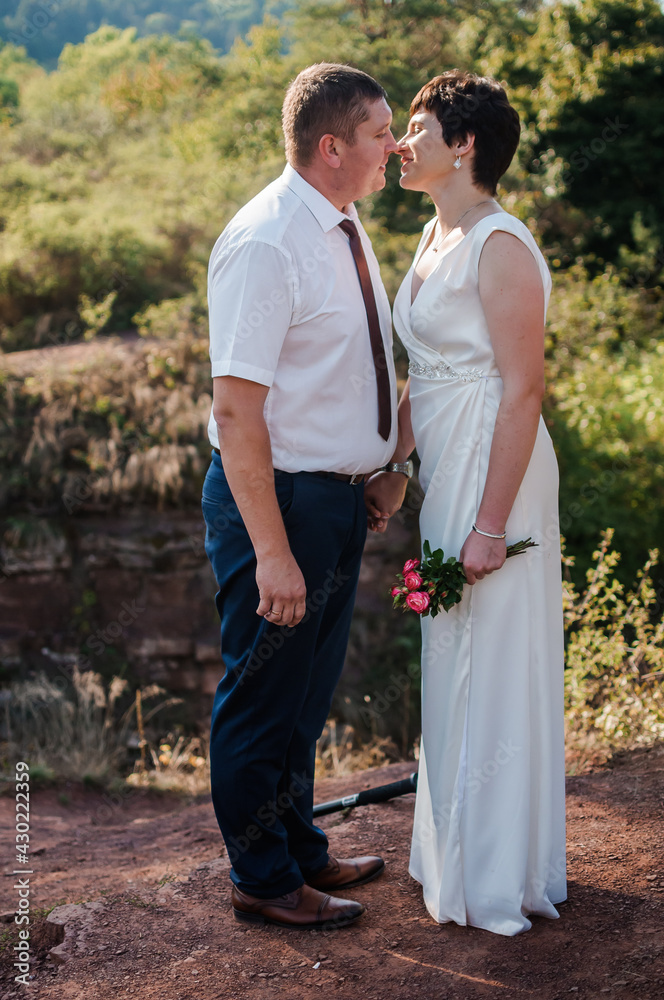 Newlyweds hold hands on the background of the forest Newlyweds hold hands on the background of the forest