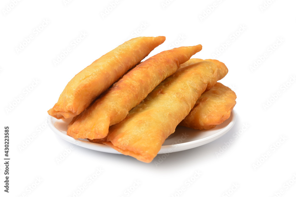 freshly baked pasties on a white plate isolated on a white background.