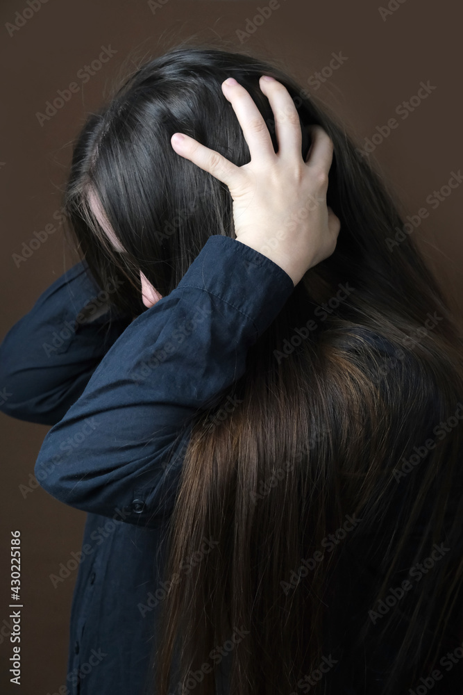 Fototapeta premium close-up girl, woman under pressure of various life problems in despair covered her face, which was distorted by protest, concept of suffering from stress, psychological violence, abuse
