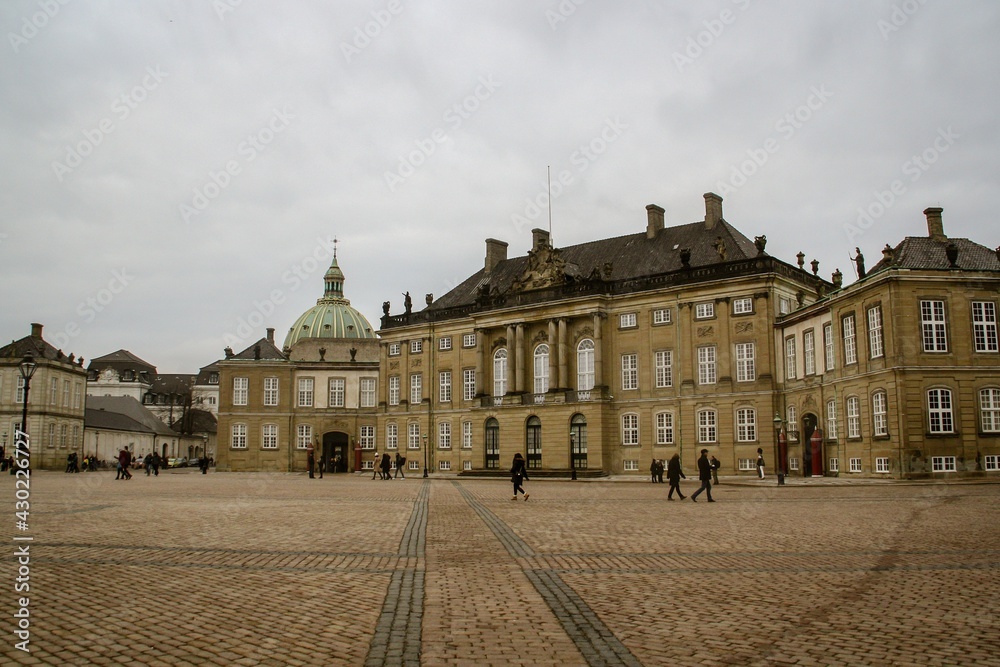 Palacio de Amalienborg, hogar de la familia real danesa y la cúpula de la iglesia de Frederik en Copenhague, Dinamarca. Turistas que visitan este famoso lugar en un día nublado de invierno.