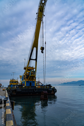 Batumi, Georgia - 08 February 2021: Yellow crane in a cargo port, industrial scene